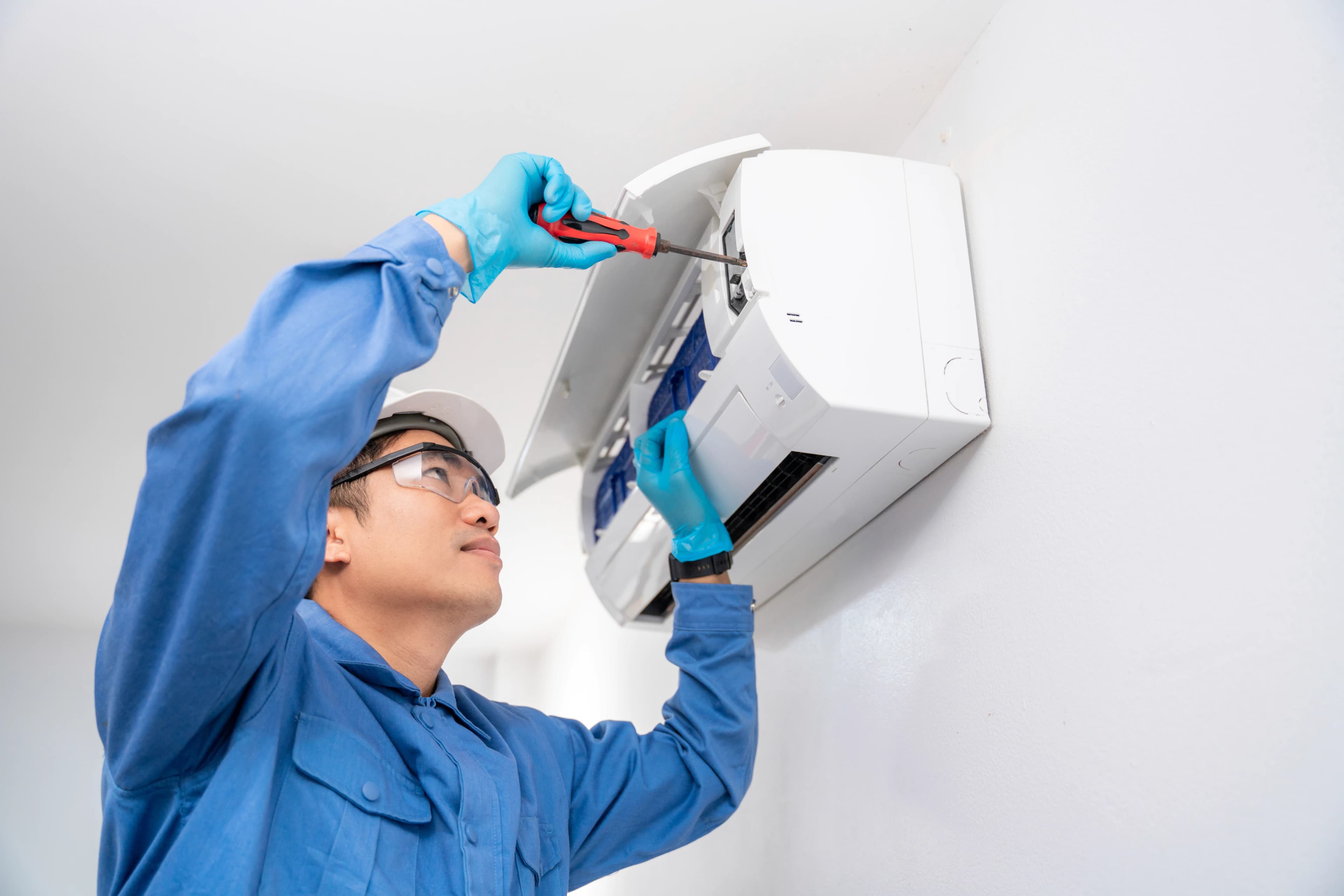 HVAC technician servicing a wall mounted air conditioner